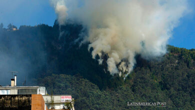 Una gran columna de humo se eleva sobre la montaña debido a un incendio forestal en un sector de los cerros orientales hoy, en Bogotá (Colombia).
