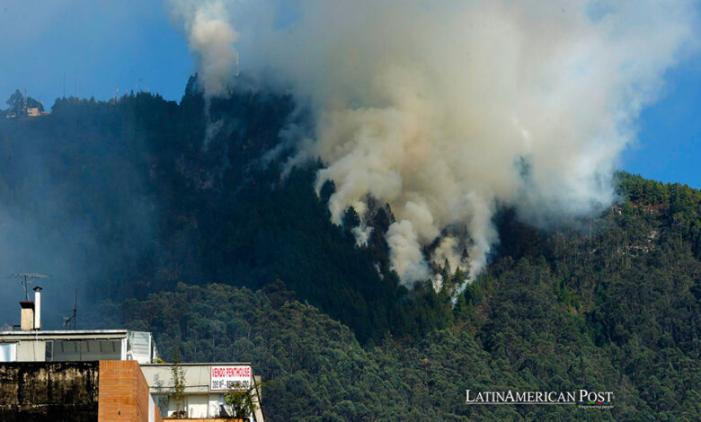 Una gran columna de humo se eleva sobre la montaña debido a un incendio forestal en un sector de los cerros orientales hoy, en Bogotá (Colombia).
