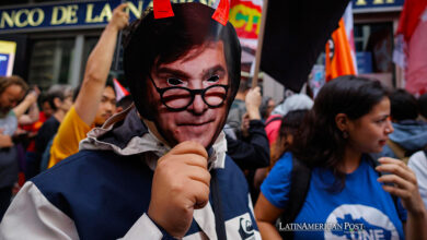 Un manifestante con una mascara de Milei se reúne hoy, frente al consulado argentino