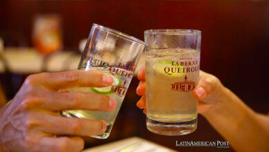 Una pareja brinda con dos vasos de "Chilcano" elaborado con pisco en el antiguo bar "Queirolo"