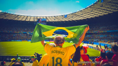 Hincha sosteniendo una bandera de Brasil