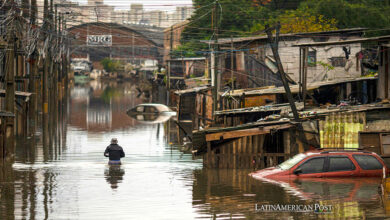 Una mujer camina en medio de una zona afectada por las inundaciones, en la ciudad de Porto Alegre