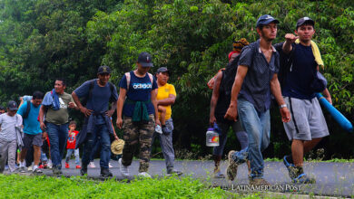 Migrantes caminan en caravana por una avenida, este sábado en el municipio de Huixtla en Chiapas (México)