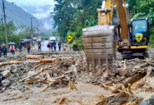 Fotografía cedida por el Ministerio de Obras Públicas que muestra trabajadores mientras operan maquinaria con la que intentan limpiar zonas afectadas por las lluvias en la ciudad de Baños (Ecuador).