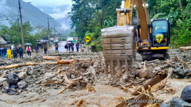 Fotografía cedida por el Ministerio de Obras Públicas que muestra trabajadores mientras operan maquinaria con la que intentan limpiar zonas afectadas por las lluvias en la ciudad de Baños (Ecuador).