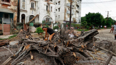 Un hombre limpia los escombros de una vivienda afectada por las fuertes lluvias, este domingo en La Habana (Cuba).