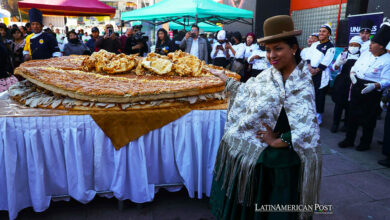 Una mujer aimara posa junto al Sándwich de chola más grande del mundo, este martes en La Paz (Bolivia).