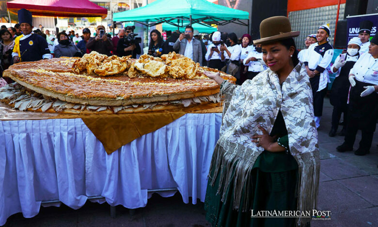 Una mujer aimara posa junto al Sándwich de chola más grande del mundo, este martes en La Paz (Bolivia).