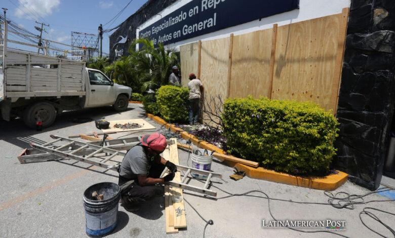 Trabajadores colocan tablas de madera para proteger un establecimiento por el paso del huracán Beryl, este miércoles en Cancún (México).