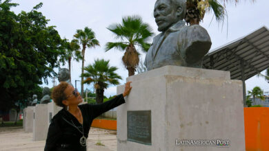 La salsera Choco Orta posa junto a un busto del cantante Ismael Rivera el 10 de julio de 2024, en la Plaza de los Salseros en San Juan (Puerto Rico).