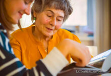 Grandmother and her young granddaughter spent great time together, family members look at photos from the youth of an elderly parent, through the pages of the album and recall funny stories from life.