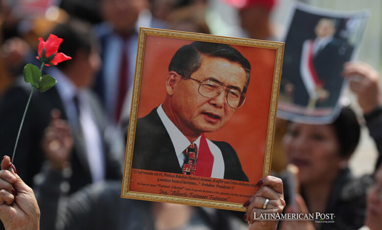 Simpatizantes del fallecido expresidente de Perú Alberto Fujimori sostienen retratos de Fujimori en una fila para asistir a su velatorio este jueves, en Lima (Perú).